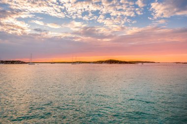 Gün batımını sakin suyun üzerinde ve yelkenli teknelerle, Bahamalar 'da bir yelkenli gezisinde ele geçirdiler.