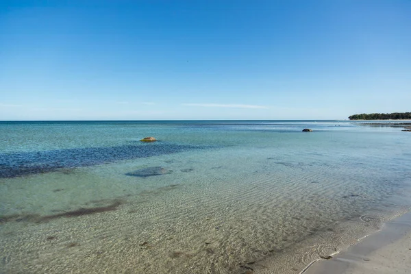 澄んだ青い空と明るい春の日に穏やかな水とロンリー 浅い砂浜 ボルンホルムのデンマーク島への旅行で捕獲された — ストック写真
