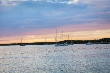 Gün batımını sakin suyun üzerinde ve yelkenli teknelerle, Bahamalar 'da bir yelkenli gezisinde ele geçirdiler.