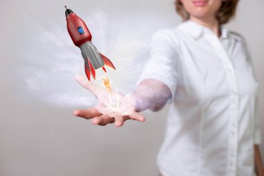 Womans hand with red flying rocket.  clipart