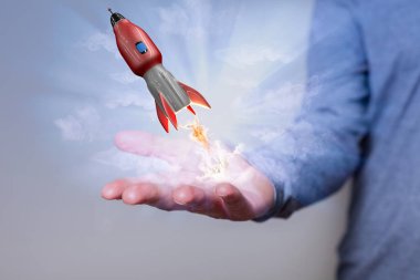 Mans hand with red flying rocket.  clipart