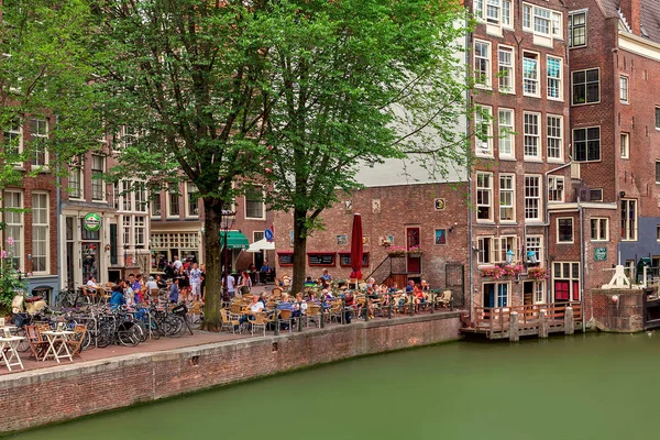 Emberek ülnek a szabadtéri étteremben Amszterdamban. — Stock Fotó