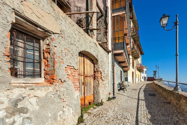 Vecchie case e stretta strada acciottolata nella città di La Morra, Italia . Foto Stock Royalty Free