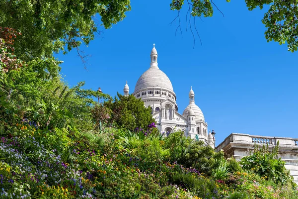 A párizsi Sacre-Coeur-bazilika és a zöld virágágyásba. — Stock Fotó