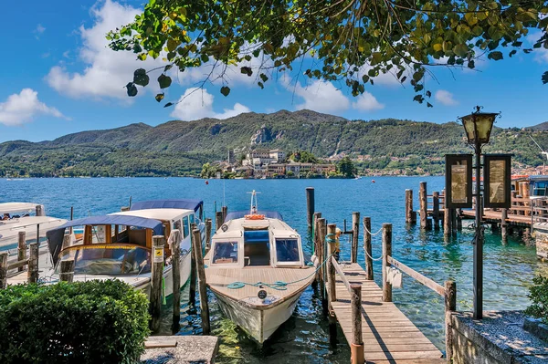 Barche ancorate lungo il molo in legno sul Lago d'Orta in Italia . — Foto Stock