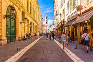 NICE, FRANCE - SEPTEMBER 02, 2015: People walking on narrow street in old tourist part of Nice - fifth most populous city and one of the most visited cities in France, receiving 4 million tourists every year.