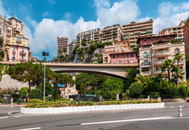 MONTE CARLO, MONACO - 13 Temmuz 2013: Bugatti yarış arabasındaki William Grover-Williams heykelinin arkasındaki renkli binalar ve köprü - 14 Nisan 1929 tarihinde Monako Grand Prix 'nin ilk kazananı.