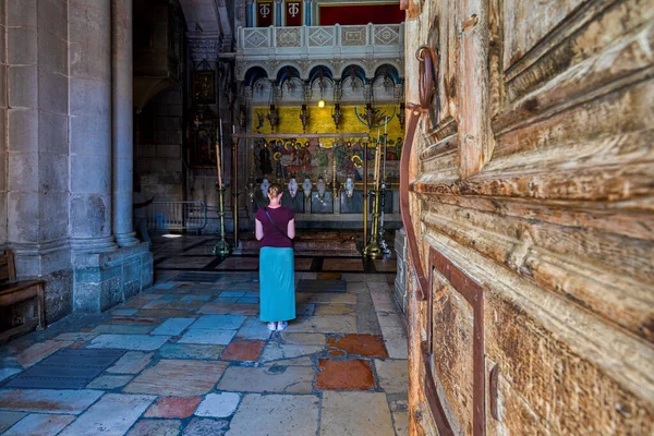 JERUSALEM, ISRAEL - 14 Temmuz 2019: Kutsal Mezar Kilisesi 'nin içinde İsa' nın bedeninin gömülmeye hazırlandığı yer olan Kutsama Taşı 'nın önünde duran kadın.