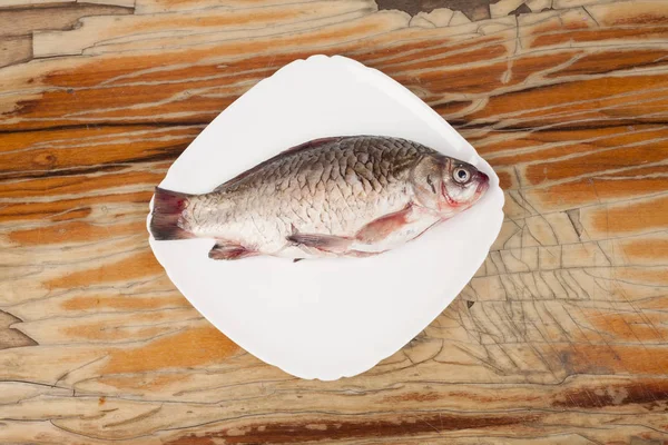 Ryba na bílém štítku na dřevěné pozadí — Stock fotografie