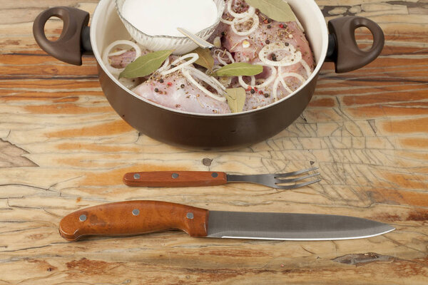 raw rabbit on a wooden Board with ingredients for stewing onion,