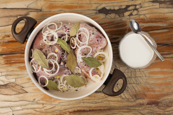 raw rabbit on a wooden Board with ingredients for stewing onion,