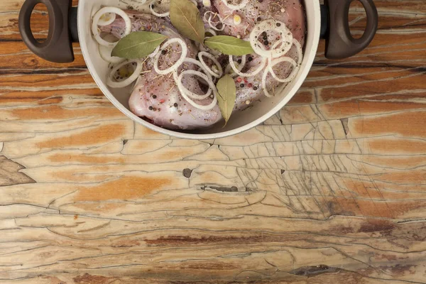 Coniglio crudo su una tavola di legno con ingredienti per stufare la cipolla , — Foto Stock