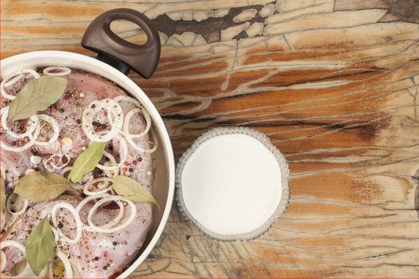 raw rabbit on a wooden Board with ingredients for stewing onion,