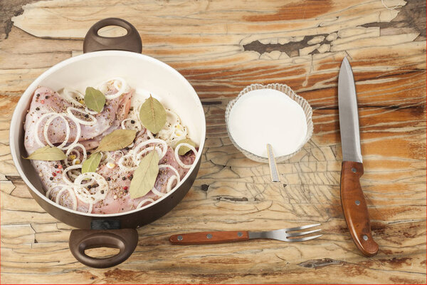 raw rabbit on a wooden Board with ingredients for stewing onion,