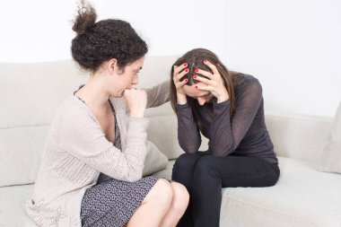 Genç bir kadın, üzgün kız arkadaşını teselli ediyor. Depresyon sorunu