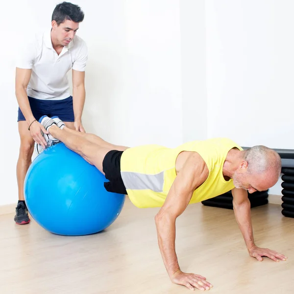 Trainer Hilft Bei Liegestützen Ball — Stockfoto