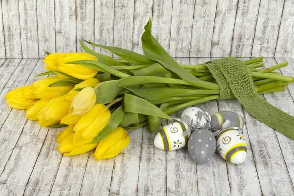 Hermosos tulipanes amarillos con huevos de Pascua — Foto de Stock