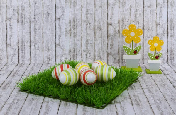 Colorful easter eggs with decorative wooden flowers — Stock Photo, Image