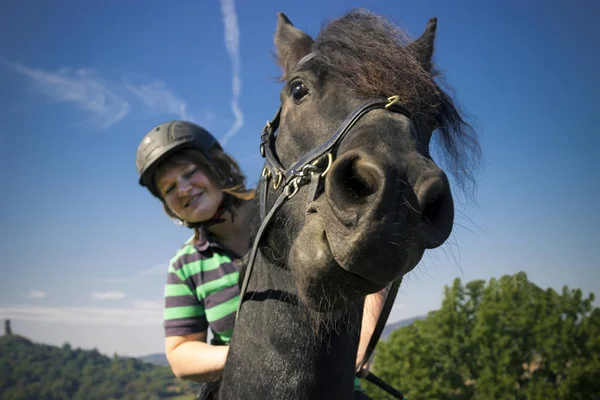Mulher bonita monta seu cavalo preto — Fotografia de Stock