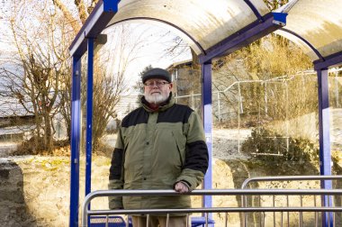 Erkek üst düzey üzerinde otobüs durağı bekliyor