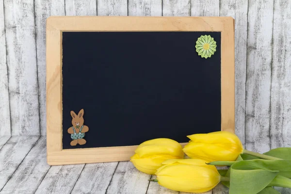 Gele tulpen met lege Blackboard — Stockfoto