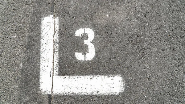 Číslo tři vyznačené na asfaltu — Stock fotografie