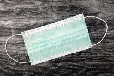 Koyu arkaplan üzerine kavramsal yüz maskesi Corona Virüsüne karşı koruma