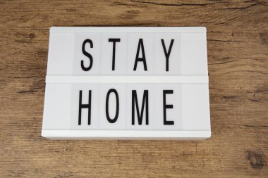 Evini ahşap bir arka plan üzerinde aydınlatma kutusunda tut