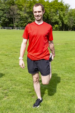 Genç yakışıklı sporcu antrenmandan önce esneme egzersizleri yapıyor.