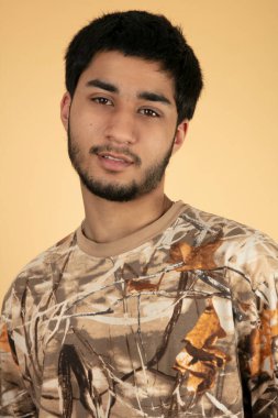 Bej arka planda arkadaş canlısı genç adam