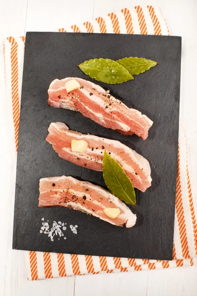Rauw varkensvlees belly met gemalen peper, grof zout, knoflook en — Stockfoto