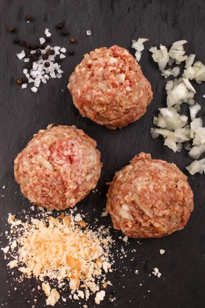 Runda köttbullar med hackad lök, salt, pepparkorn och bröd — Stockfoto