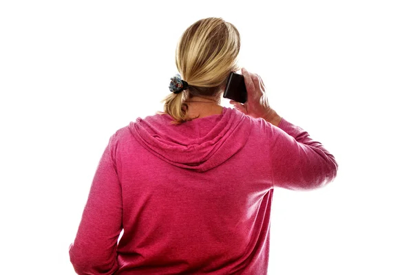 Achteraanzicht van een blonde vrouw senior met behulp van de mobiele telefoon — Stockfoto