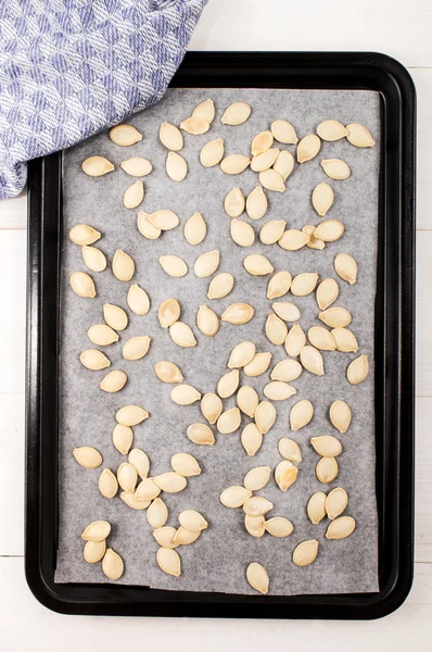 Сире гарбузове насіння на кухонному папері та смаженому лотку — стокове фото