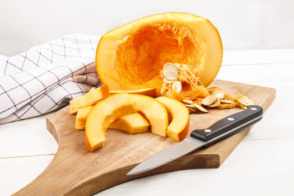 Organic freshly harvested hokkaido pumpkin cut into wedges on a — Stock Photo, Image