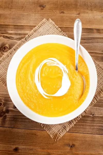 Homemade pumpkin soup with cream fresh in a deep plate on jute — Stock Photo, Image