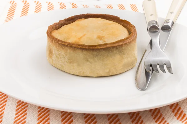 Νωπά ψημένα σκωτσέζικη πίτα με μαχαίρι και πιρούνι σε ένα πιάτο — Φωτογραφία Αρχείου