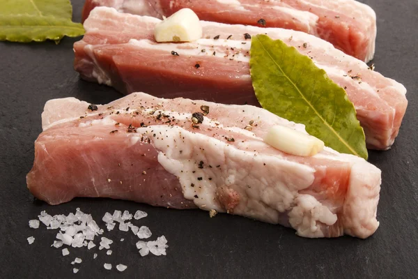 Barut baharat ve defne yaprağı ile üzerinde domuz eti şeritler — Stok fotoğraf