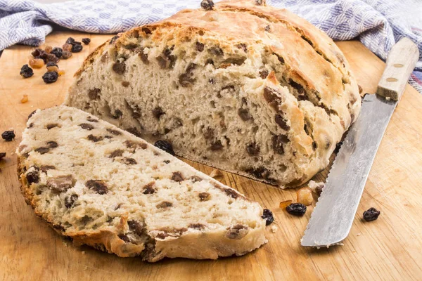 Rebanada de pan de pasas con cuchillo de pan en una tabla de madera —  Fotos de Stock
