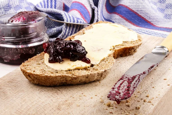 Irish soda bread with blackcurrant marmalade on a wooden plate — Stock Photo, Image