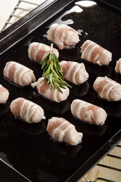 Lilla irländska korvar lindade med bacon på en rostning bricka — Stockfoto