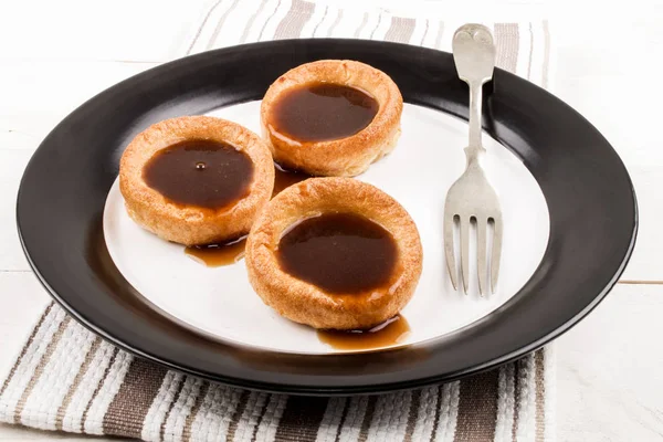 Freshly baked yorkshire pudding with gravy on a plate — Stock Photo, Image