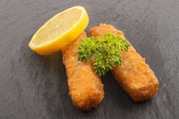 Dedo de pescado con perejil y limón sobre pizarra —  Fotos de Stock
