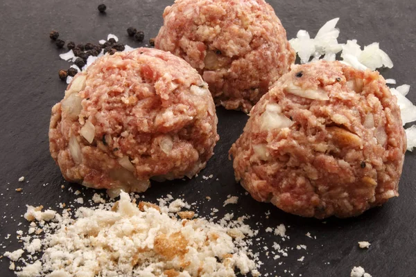Raw meat ball with black peppercorn, onion and bread crumbs — Stock Photo, Image