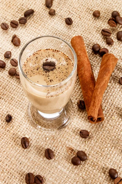 Licor de crema de café en un vaso con granos de café y canela —  Fotos de Stock