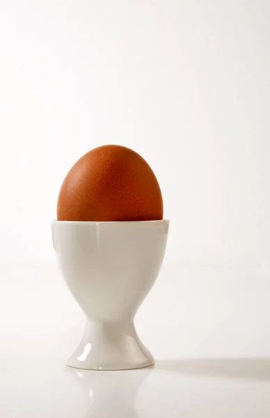 Boiled egg in a porcelain egg cup — Stock Photo, Image