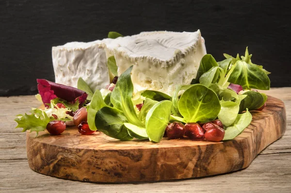 Camembert with salad and cranberry seed on wooden board — Stock Photo, Image