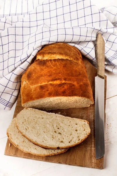 Zelfgebakken brood brood gesneden op een houten plank met mes — Stockfoto