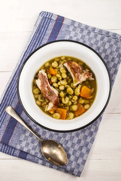 Sup kacang dengan daging babi asap dan wortel dalam mangkuk enamel — Stok Foto