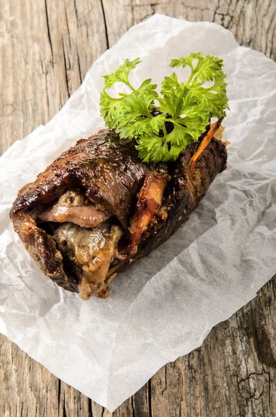 Freshly roasted beef roulade with parsley on kitchen paper — Stock Photo, Image